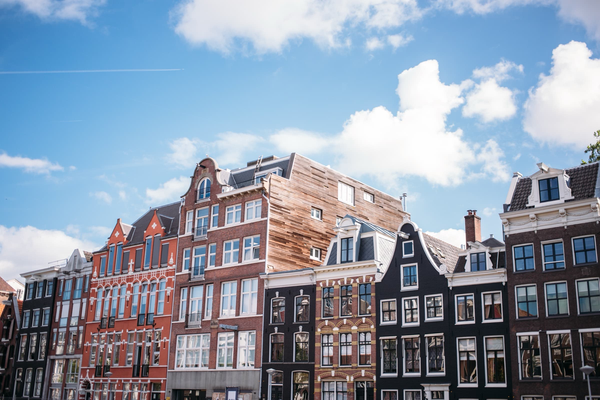 Klassieke Amsterdamse grachtenpanden tegen een strakblauwe lucht