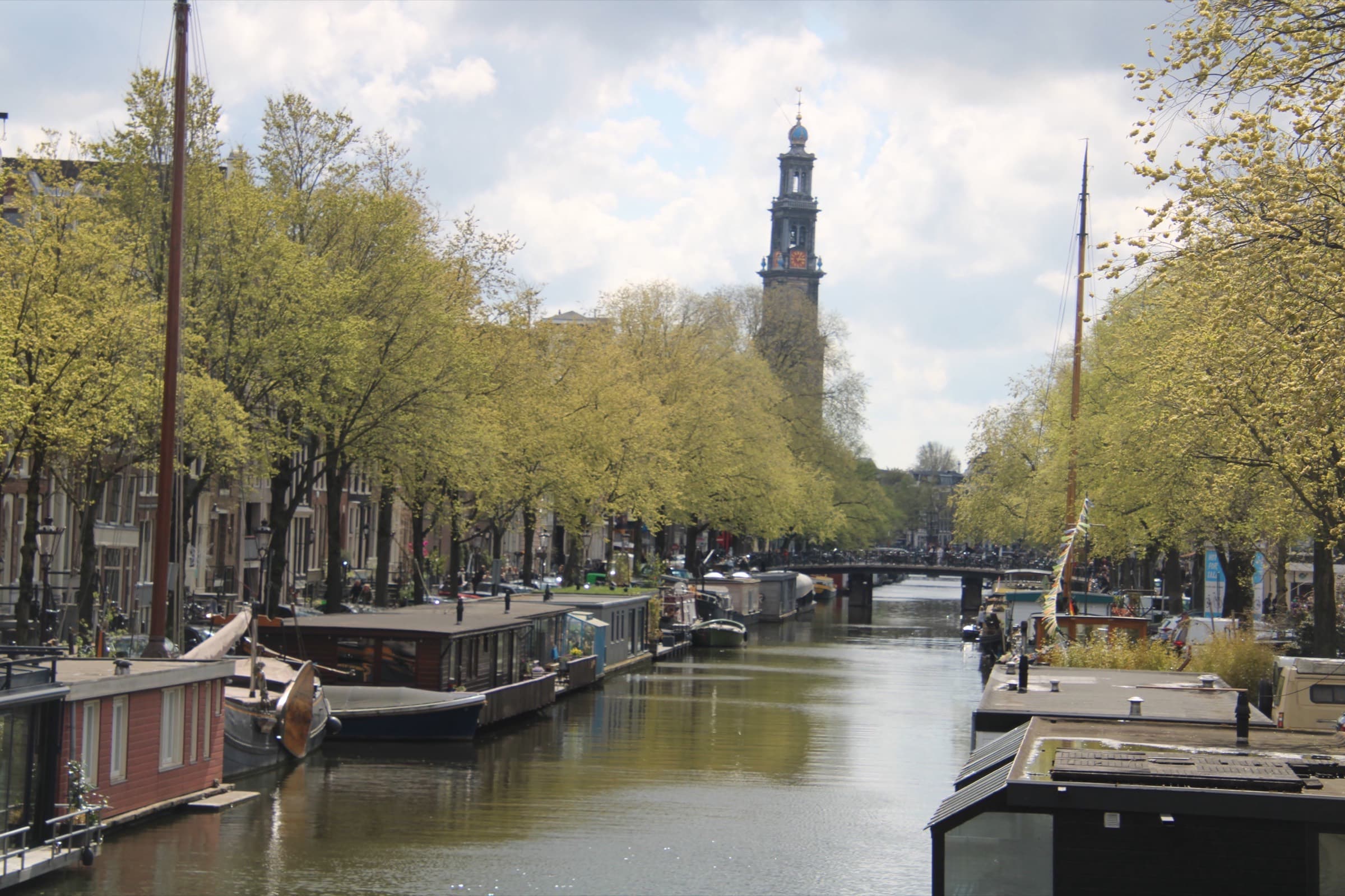 Amsterdamse gracht met woonboten en de Westertoren op de achtergrond